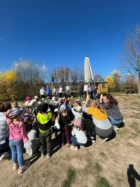 Kindergruppe im Garten hebt gemeinsam die Hände