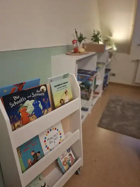 Kinderbücher in weißem Regal in gemütlicher Leseecke